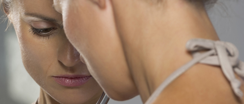 a close-up of a woman looking into a mirror