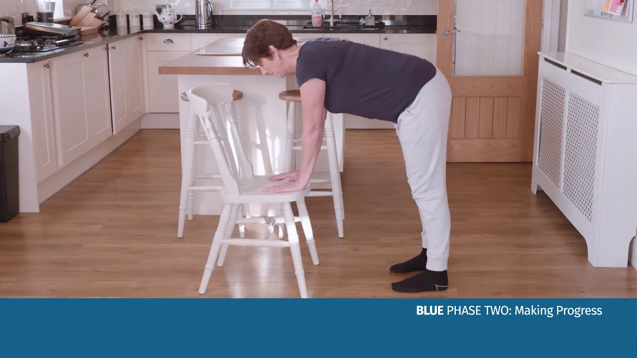 en kvinne som bøyer seg over en stol