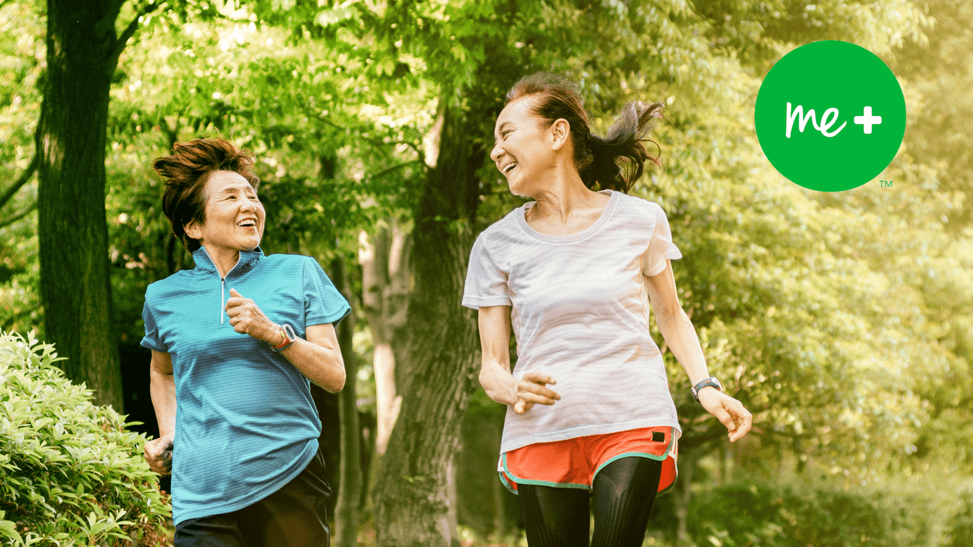 a couple of women playing frisbee in the woods