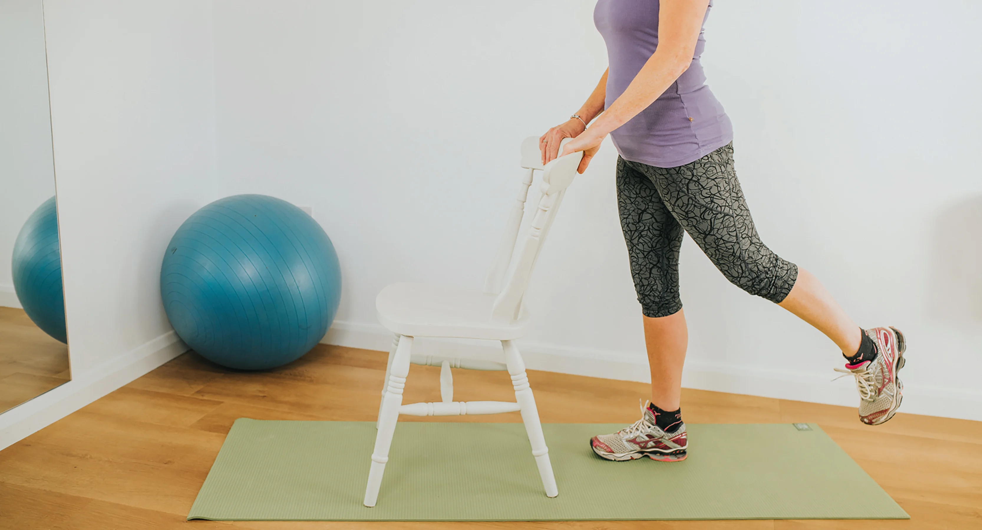 a person standing on a stool with a ball on it