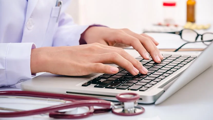 een persoon die op een laptop typt