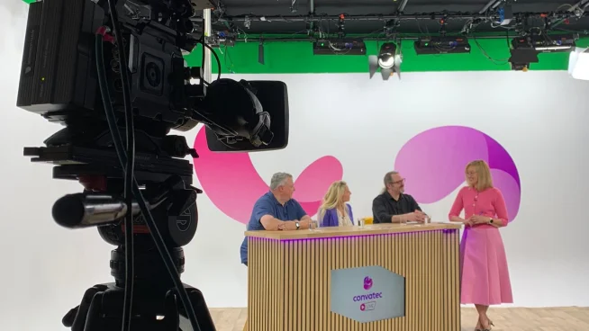 Bild des Convatec LIVE Filmstudios auf dem verschiedene Expert:innen an einem Tisch stehen und mit der Moderatorin diskutieren