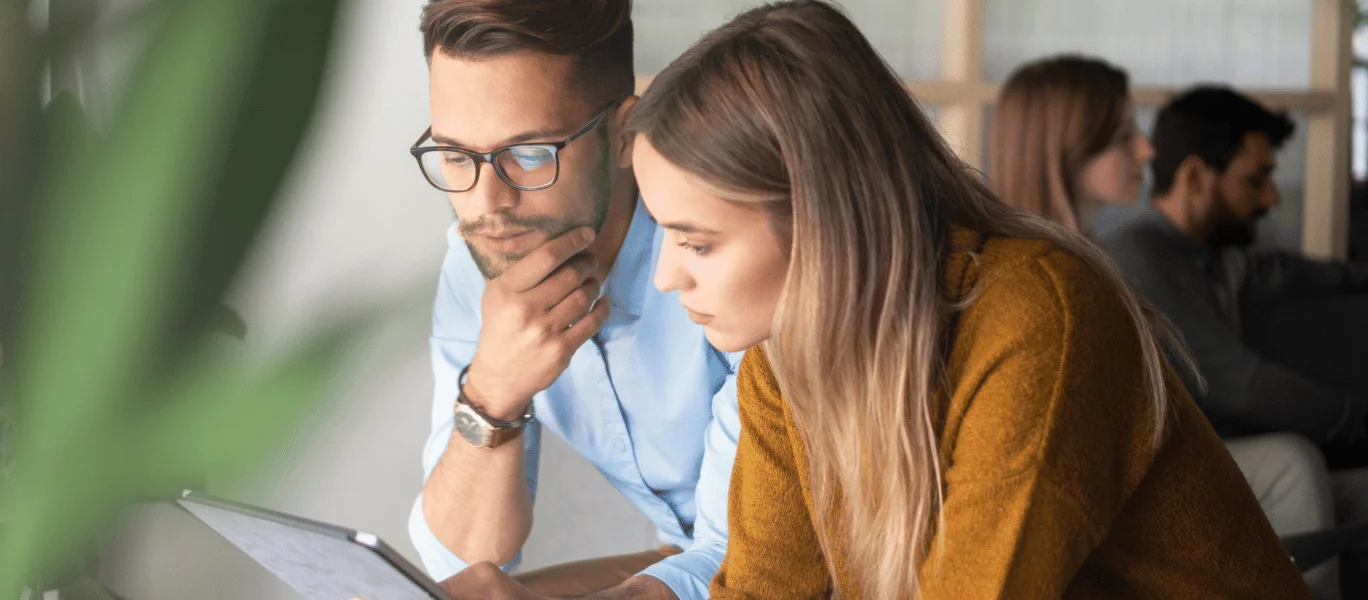 Muž a žena hledící na obrazovku počítače