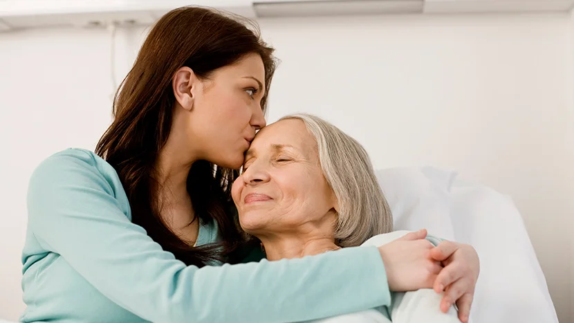 bir kadını yanağından öpen bir kadın