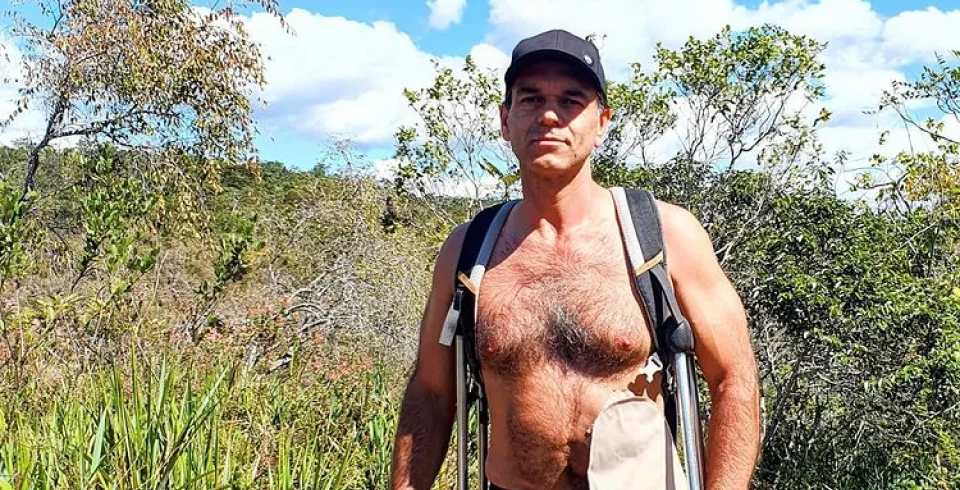 un uomo con uno zaino e un cappello in piedi in un campo