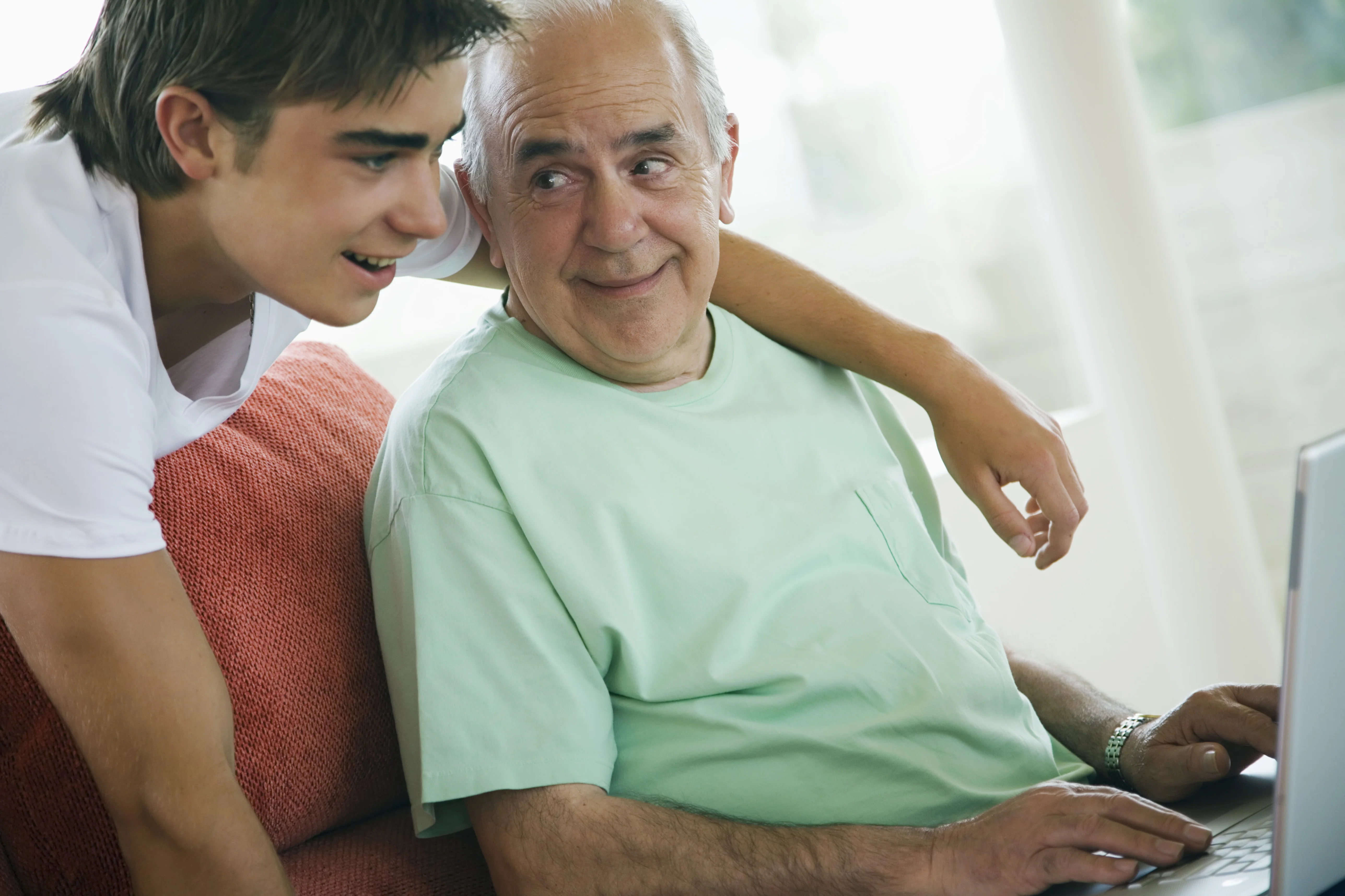 a boy and a man looking at a computer screen